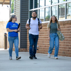 Three students walking on campus.