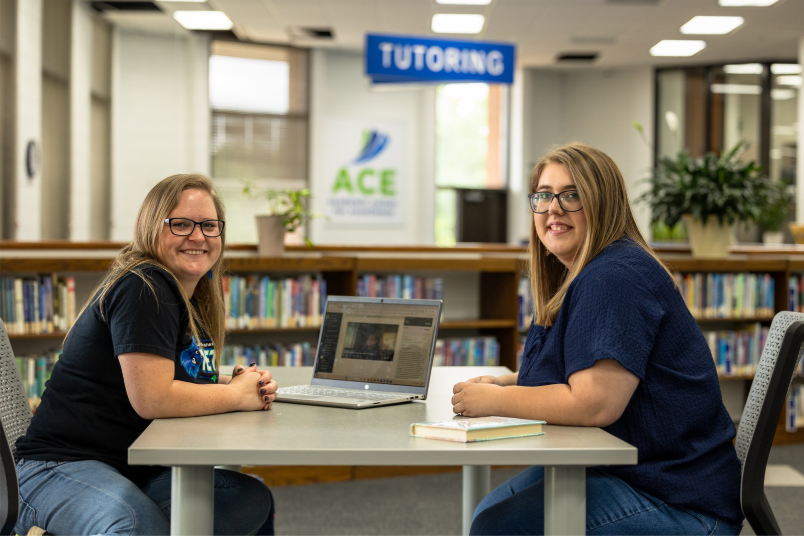 Two students at table.