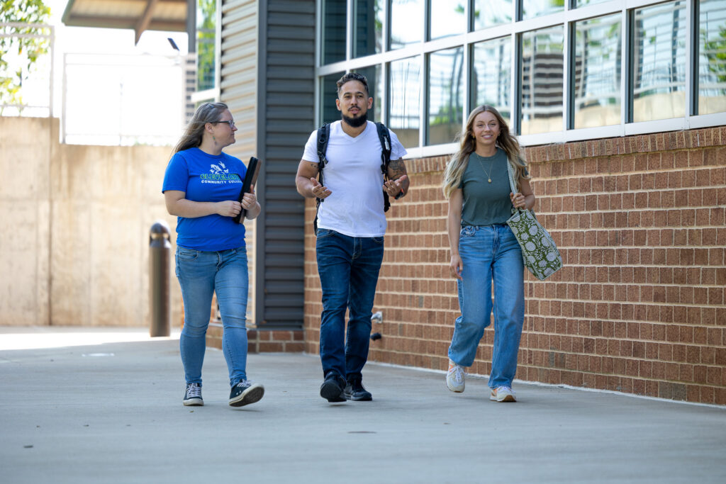 Three students walking on campus.