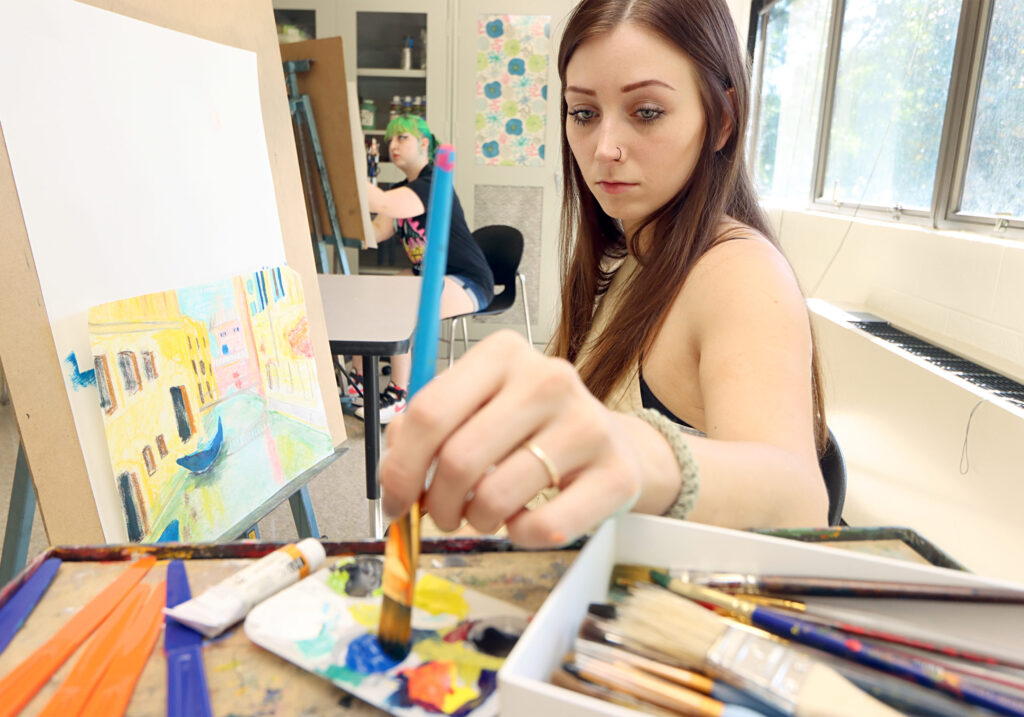 Art student painting at an easel