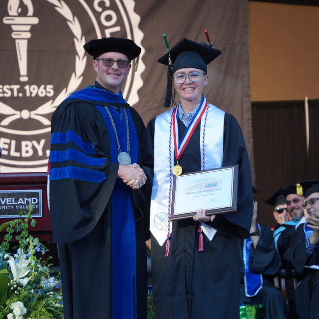 Mallory McMahan Cook poses with Dr. Hurst on stage at the 2026 commencement ceremony.