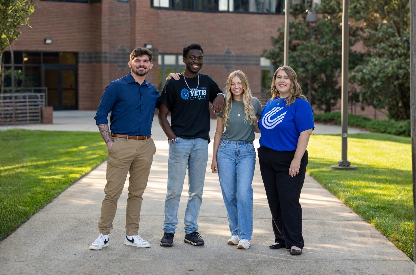 A group of students standing on a walkway in front of a school building